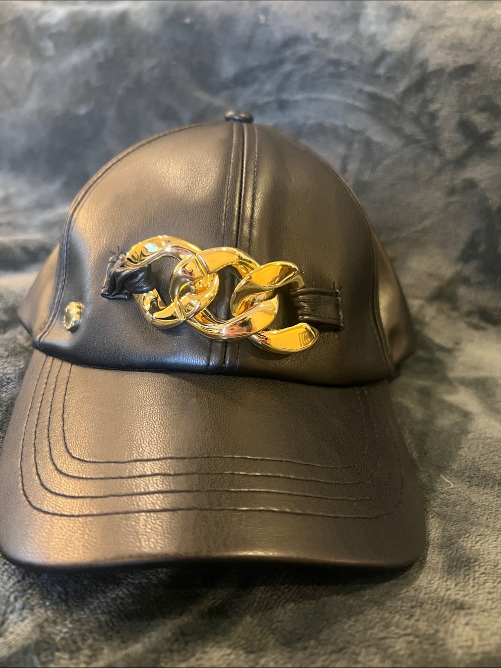 BCBG Black Faux Leather Cap with Gold Chain Detail